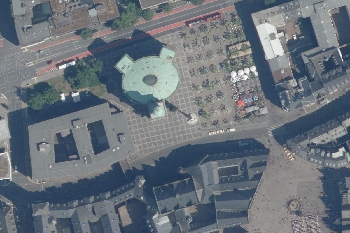 Ausschnitt in Originalauflösung: die runde Paulskirche mit grünem Kupferdach und Turm, daneben der Paulsplatz mit Bäumen und Sonnenschirmen, Straßen mit Bussen und Autos, unten die Dächer am Römerberg.