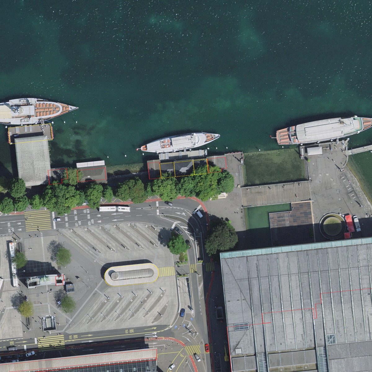 Luftbild am Luzerner Seeufer mit Schiffsanlegestellen, Raddampfern und Busbahnhof; dünne rote und gelbe Linien zeichnen die Umrisse der Gebäude nach und liegen genau auf den Dachkanten und Mauern.